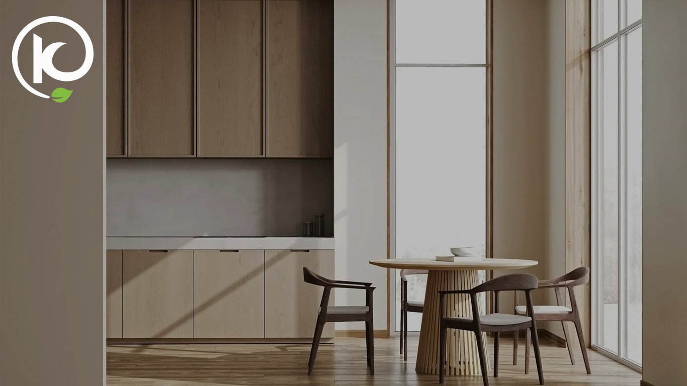 Light timber kitchen cabinets and round dining table, darkened, with a logo in the top corner